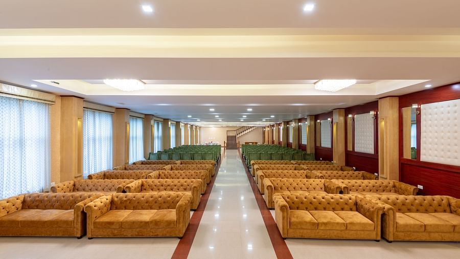 Image of an expansive banquet hall featuring brown and green sofas at DLS Tehri Club Resort.